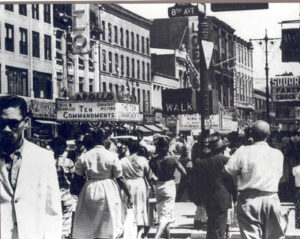 Many people walking on a busy 125th street in Harlem, NY